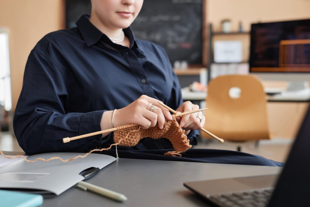 young-woman-knitting-or-crocheting-at-workplace-2025-03-06-13-05-35-utc-min